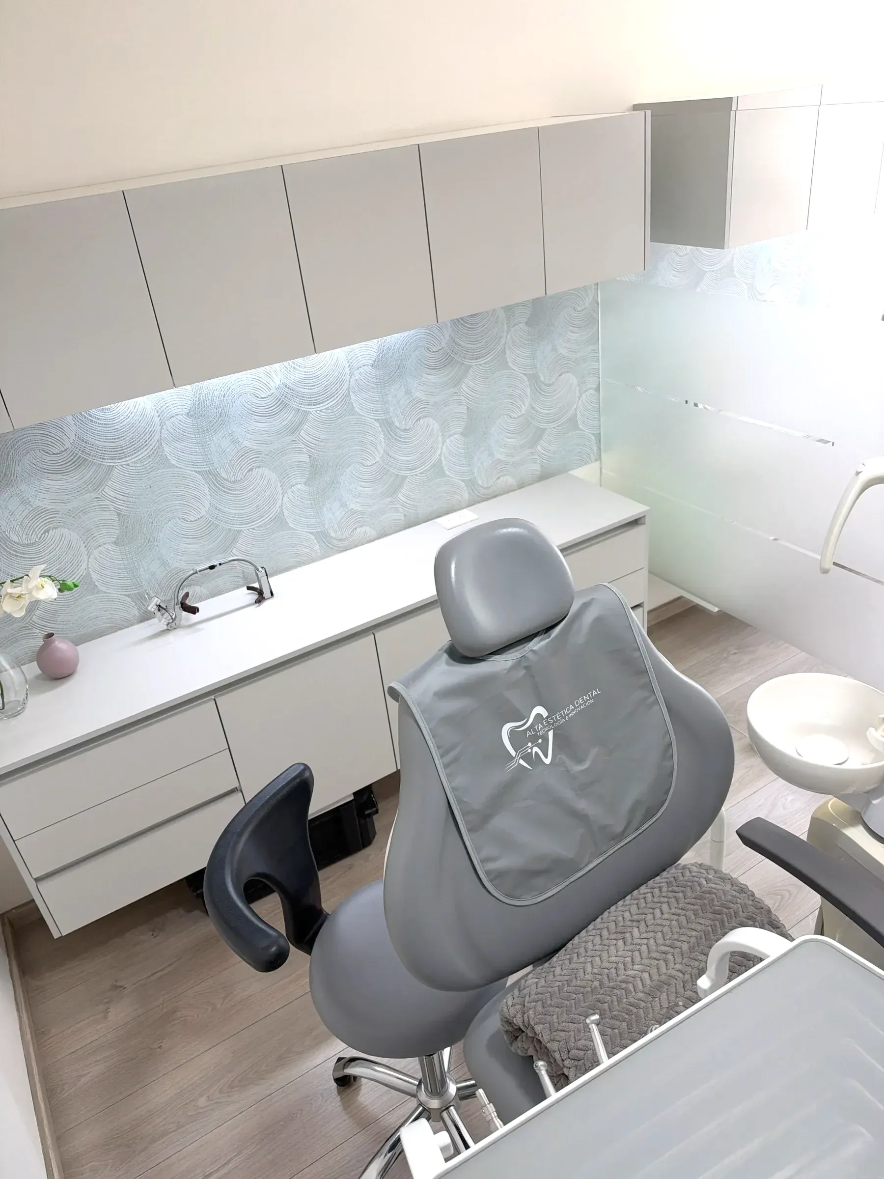 Consultorio de Alta Estética Dental, con su logotipo en el cabecero del sillón.